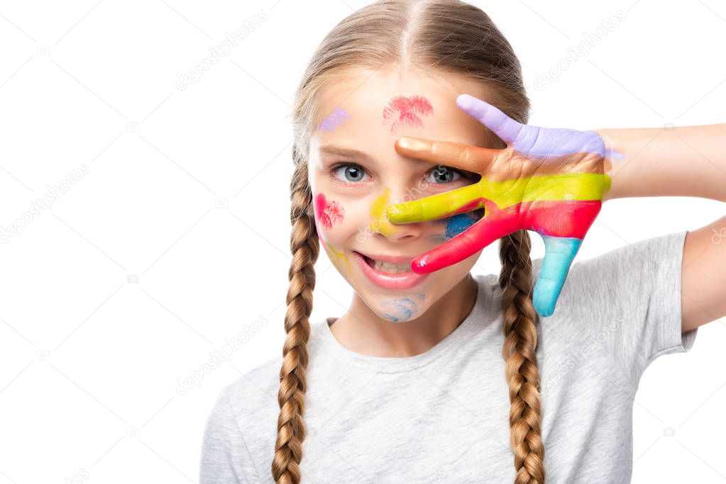 schoolchild looking at camera through colored fingers isolated on white