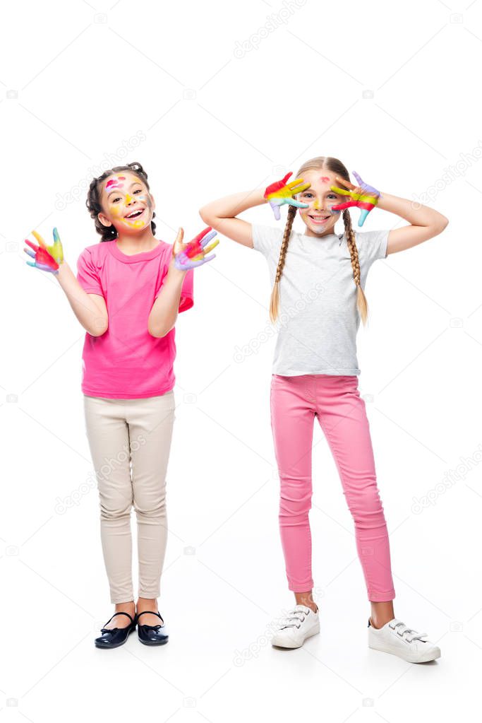 happy schoolchildren having fun with painted hands and faces isolated on white