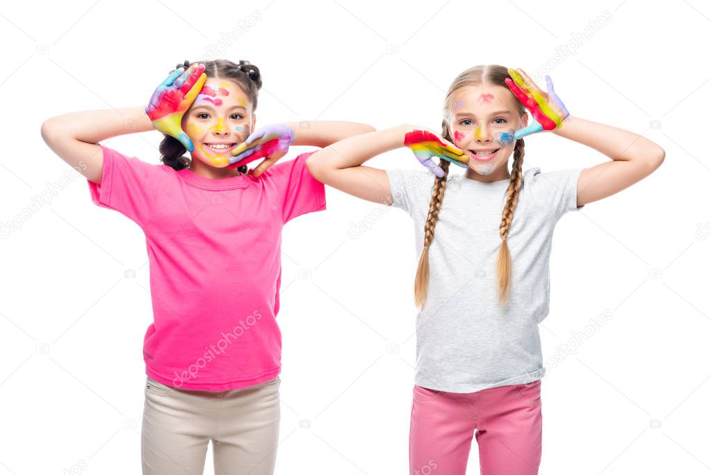 schoolchildren touching faces with painted hands isolated on white