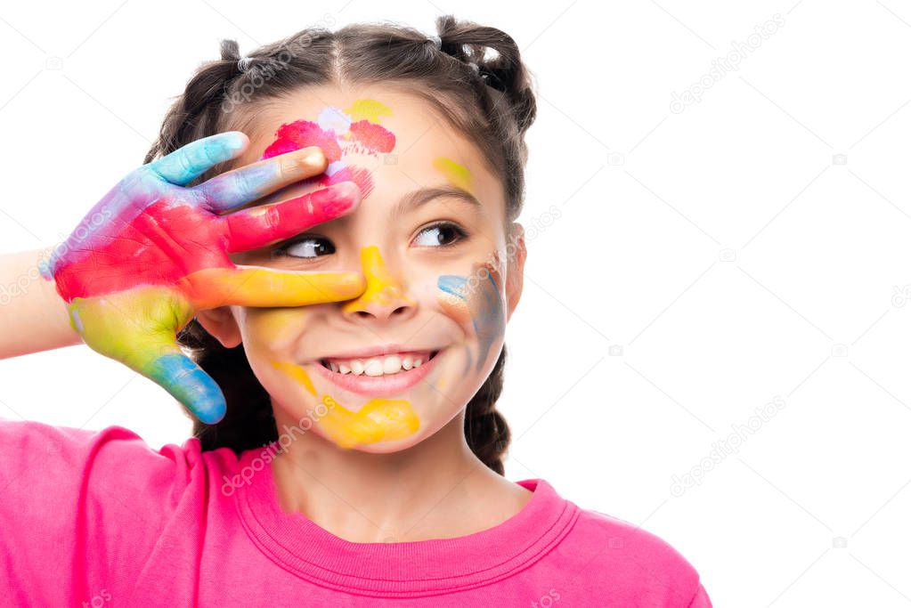 portrait of smiling schoolchild with painted face and hand looking away isolated on white