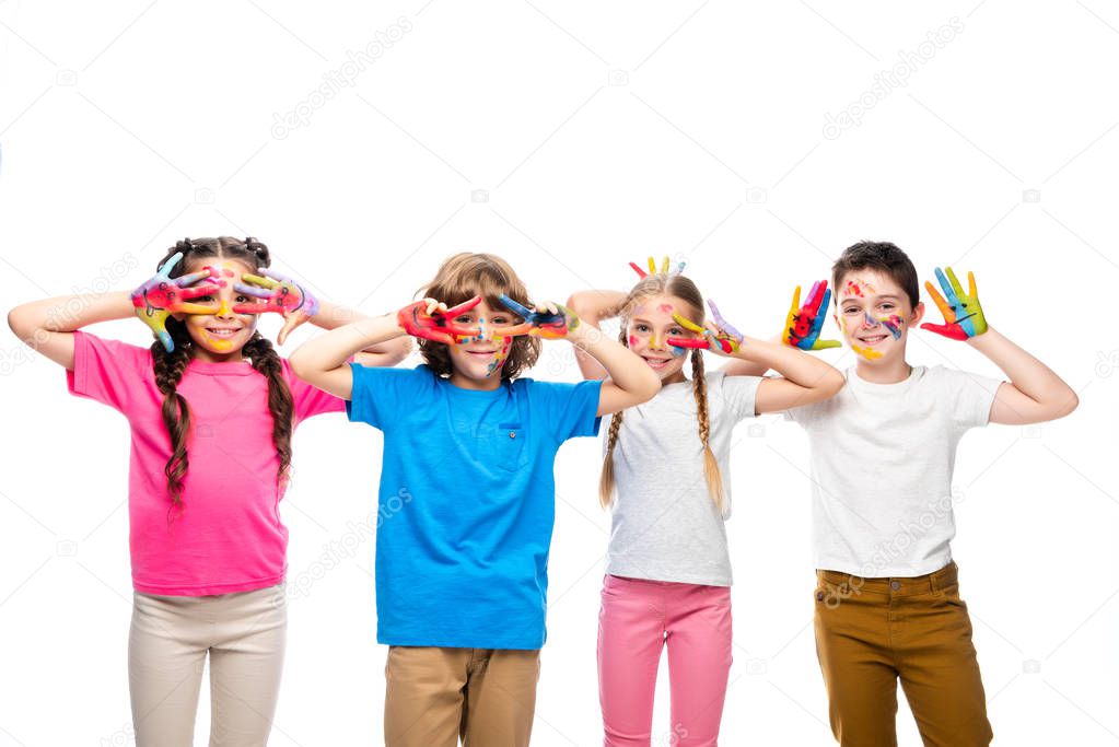 schoolchildren having fun and showing painted hands with smiley icons isolated on white