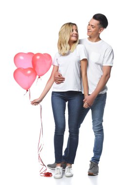 kalp balon şeklinde bohça ile çift ayakta ve birbirlerine beyaz izole bakarak