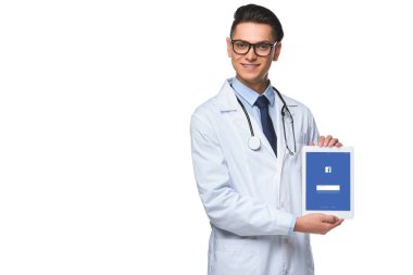 yakışıklı genç doktor beyaz izole ekranda tablet facebook app ile tutarak