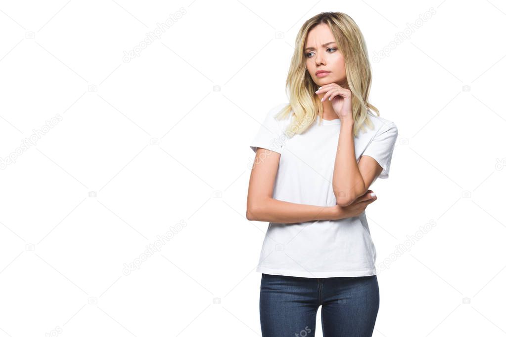 attractive pensive girl in white shirt and jeans looking away isolated on white