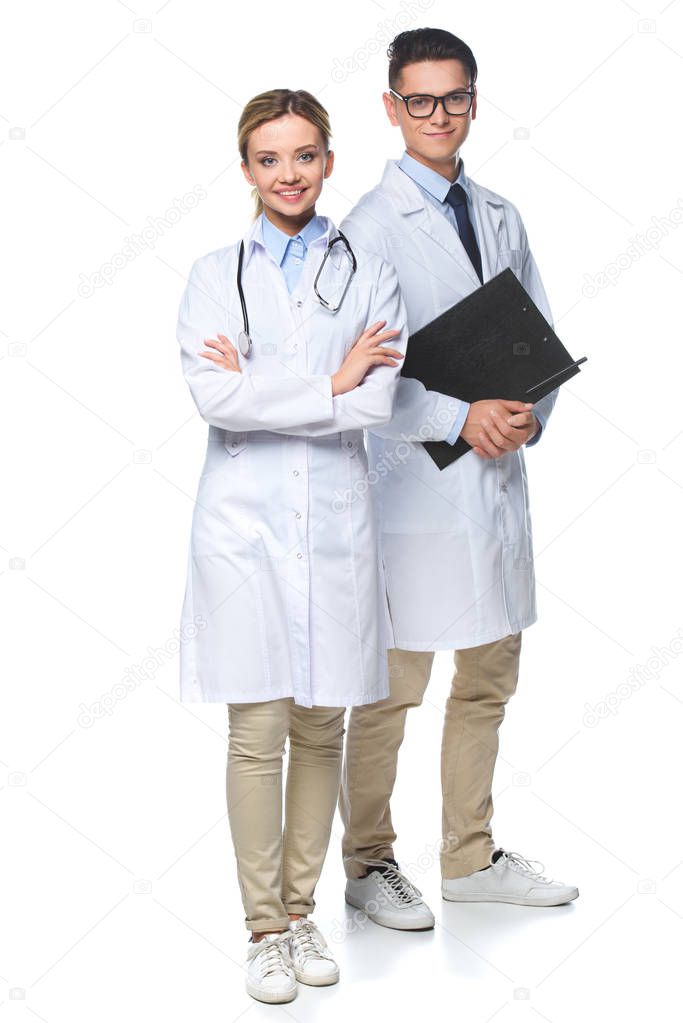 doctors standing with stethoscope and clipboard, looking at camera isolated on white