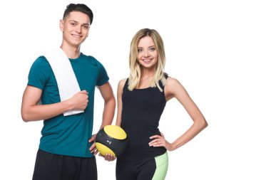 young sporty couple with fitball and towel looking at camera isolated on white clipart