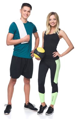 young athletic couple with fitball and towel looking at camera isolated on white clipart