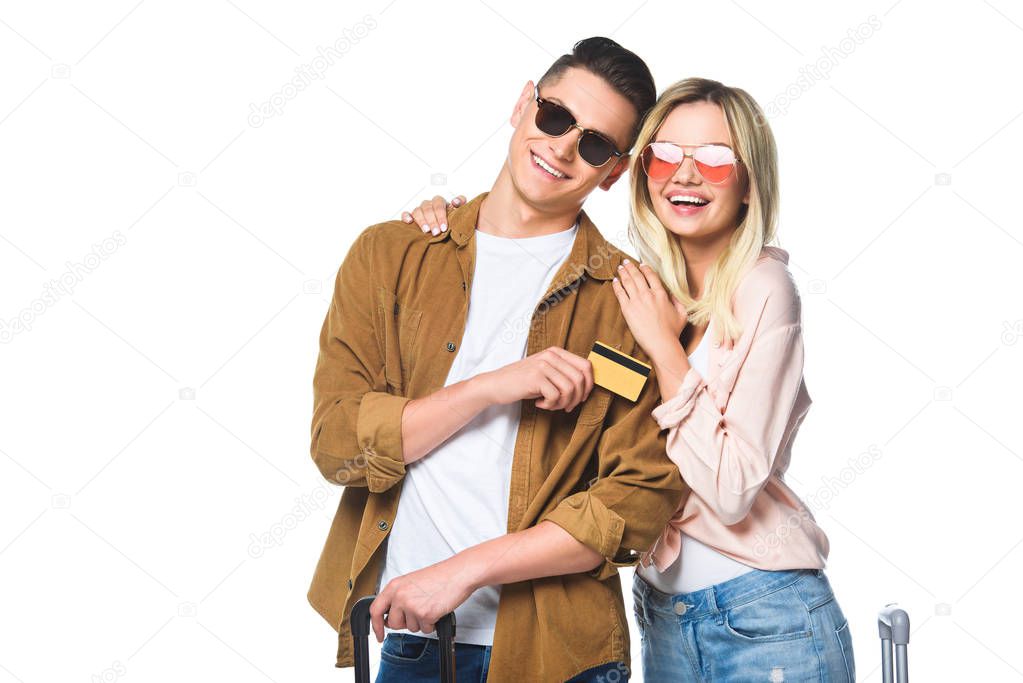 happy young travelling couple with suitcases and credit card isolated on white