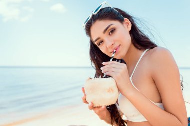 bikini içme Hindistan cevizi kokteyl sahilde güzel genç kadın