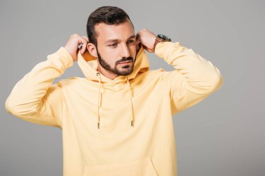 yakışıklı sakallı erkek model gri arka plan üzerinde izole sarı hoodie koyarak 