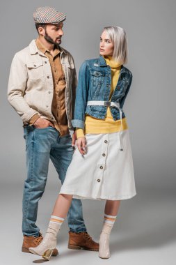 Çift sonbahar kıyafetiyle poz ve birbirine, gri bakarak