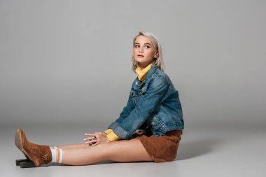 trendy kadife etek ve kot ceket, gri oturan çekici sarışın model