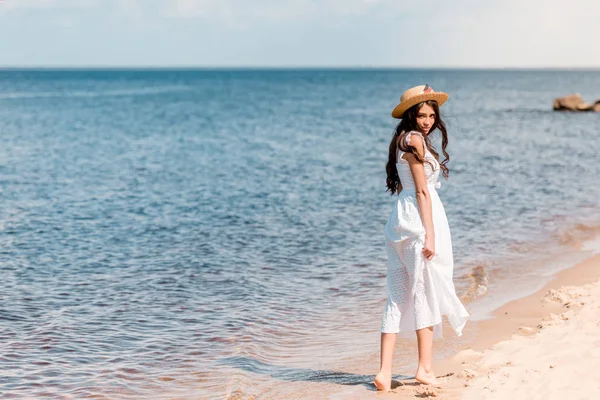 Młoda Kobieta Słomkowy Kapelusz Białą Suknię Spaceru Plaży — Zdjęcie stockowe