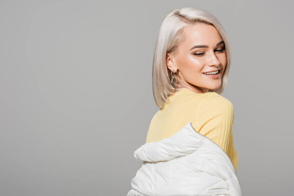 happy attractive female model posing isolated on grey background 