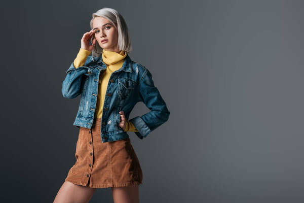 женщина в желтой водолазке, модная вельветовая юбка и джинсовая куртка, изолированная на сером
