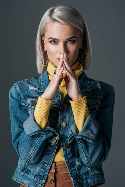 stylish woman in yellow turtleneck and jeans jacket, isolated on grey