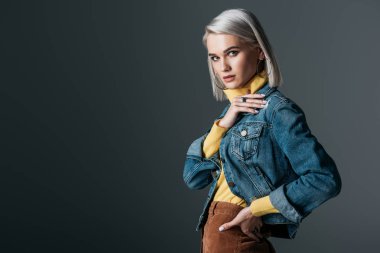 attractive girl in yellow turtleneck and fashionable jeans jacket, isolated on grey