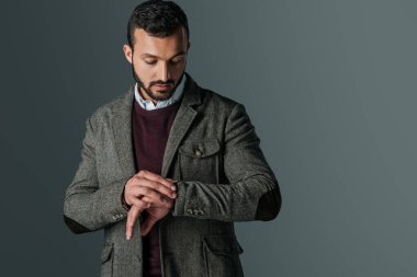 Kol saati, gri izole bakarak tüvit ceketli yakışıklı adamı