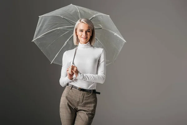 Mooi Meisje Witte Coltrui Poseren Met Transparante Paraplu Geïsoleerd Grijs — Stockfoto