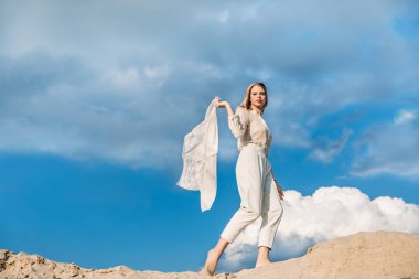 eşarp kumul üzerinde yürüme ile beyaz giysili güzel moda kızı