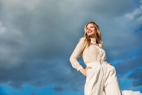 Вид Знизу Елегантна Усміхнена Дівчина Позує Білому Одязі Хмарним Небом — стокове фото