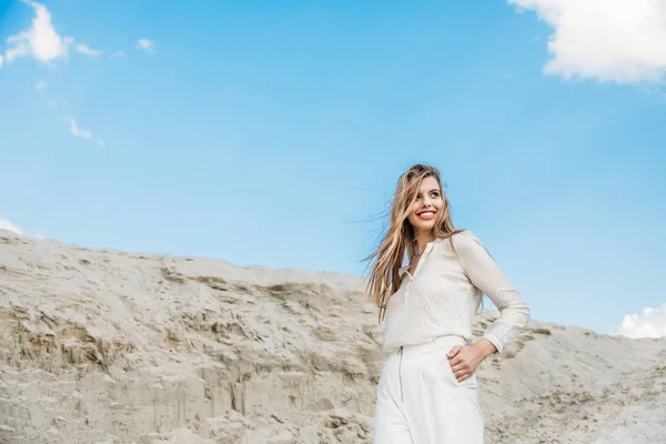 Приваблива Усміхнена Жінка Білому Стильному Одязі Позує Піщаній Дюні Блакитним — стокове фото