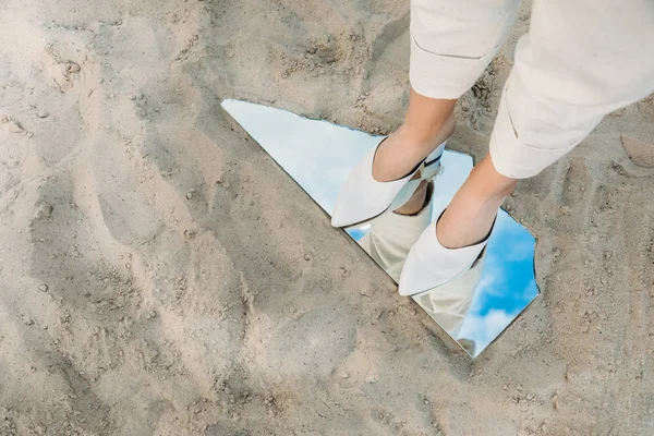 Низкая Часть Девушки Стоящей Куске Зеркала Отражением Облачного Неба Песке — стоковое фото