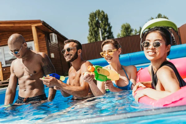 Glimlachend Multiculturele Vrienden Plezier Met Water Geweren Zwembad — Stockfoto