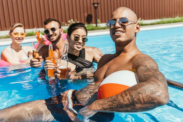 Amigos Multiétnicos Com Garrafas Cerveja Relaxante Água Piscina — Fotografia de Stock