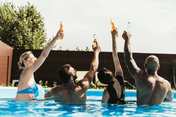Back View Multicultural Friends Rising Bottles Beer Swimming Pool — Stock Photo, Image