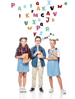 kitap tutan ve harflerin simgelerle beyaz izole kamera bakarak mutlu sınıf