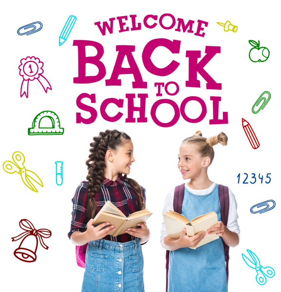 schoolchildren holding open books and looking at each other isolated on white, with "welcome back to school" lettering