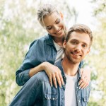 Belle jeune femme piggybackking sur son copain au parc