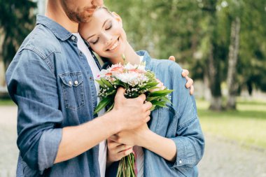 çiçek buketi Park'ta tutan güzel genç çift doz kırpılmış