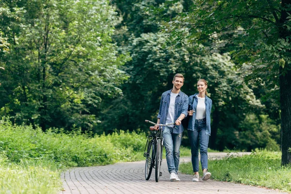 Feliz Pareja Joven Caminando Por Parque Con Bicicleta Vintage —  Fotos de Stock