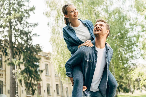 Glad Ung Kvinna Åka Snålskjuts Hennes Pojkvän Park — Stockfoto