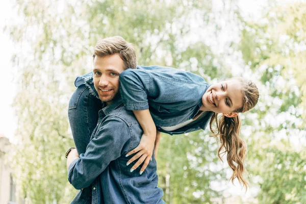 Pohledný Mladý Muž Nesoucí Jeho Usmívající Dívka Rameni Parku — Stock fotografie