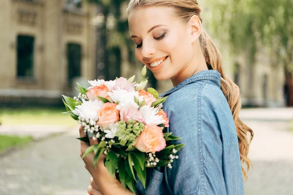 Uśmiechający Się Młoda Kobieta Patrząc Bukiet Kwiatów — Zdjęcie stockowe