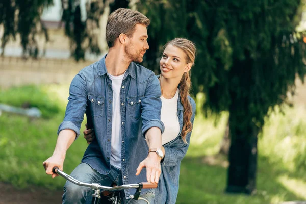 Hermosa Joven Pareja Montando Bicicleta Juntos Parque Mirándose Entre — Foto de Stock