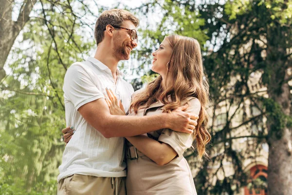 美しい若いカップルお互いを見て 公園で笑顔の底面図  — 無料ストックフォト