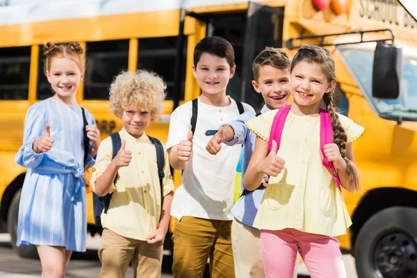 Group Happy Pupils Looking Camera Showing Thumbs Front School Bus — Stock Photo, Image
