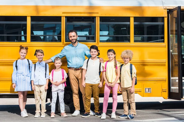 Skolbarn Och Lärare Står Tillsammans Framför Skolbuss Och Tittar Kameran — Stockfoto