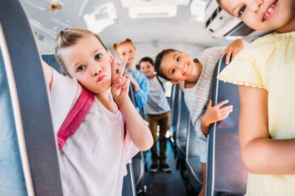 学校のバスに乗って カメラを見て幸せな小学生のグループ — ストック写真