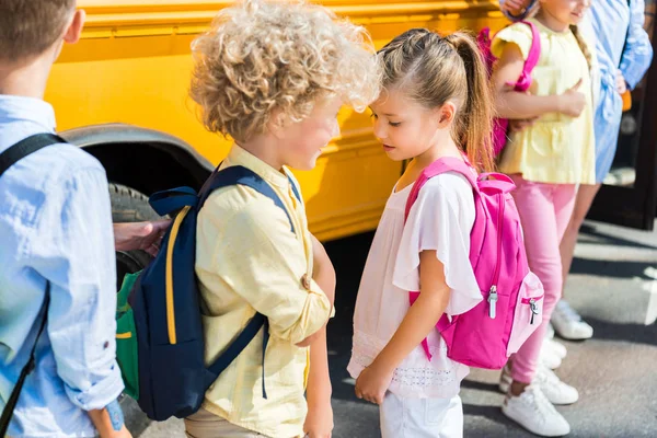 学校のバスの近くに立ってかわいい生徒のグループ  — 無料ストックフォト