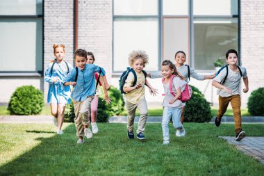 group of adorable pupils runing by school garden clipart