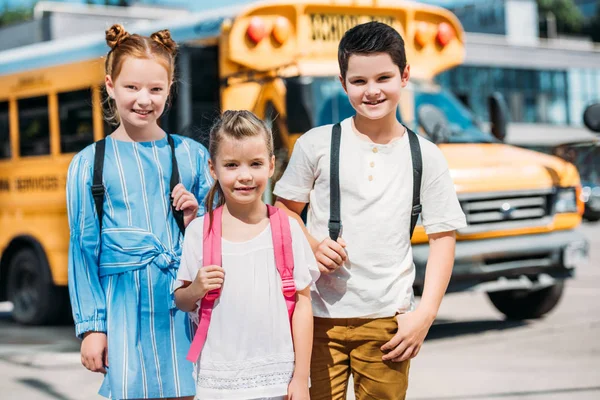 Leende Elevgrupp Tittar Kameran Framför Skolbuss — Gratis stockfoto