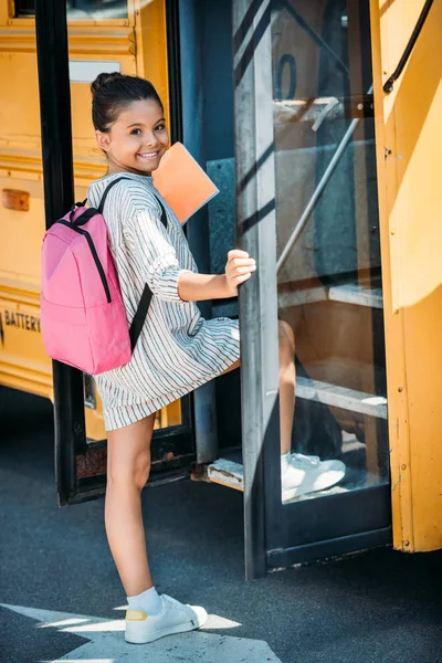 Entzückende Kleine Schülerin Betritt Den Schulbus Und Schaut Die Kamera — Stockfoto