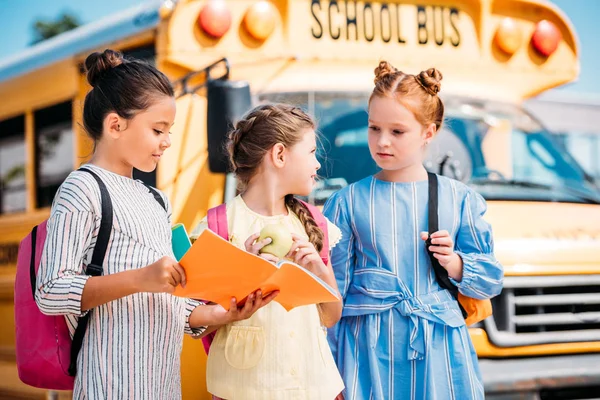 Groep Van Schattige Kleine Schoolmeisjes Met Laptop Praten Voor Schoolbus — Gratis stockfoto