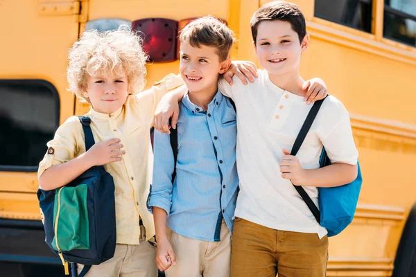 Прелестные Маленькие Школьники Обнимаются Перед Школьным Автобусом — стоковое фото