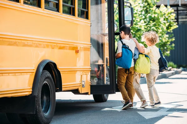 学校のバスに入る愛らしい小さな男子生徒 — ストック写真